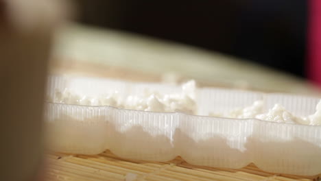 Putting-rice-in-a-plastic-shape-Cooking-sushi-rolls