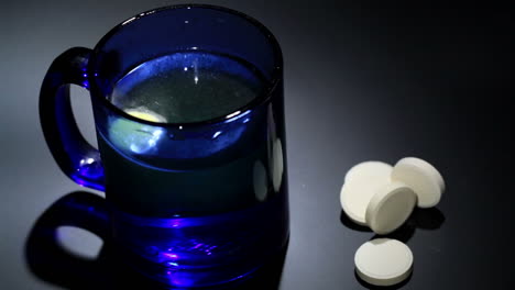 Tablet-dissolving-in-a-blue-glass-of-water