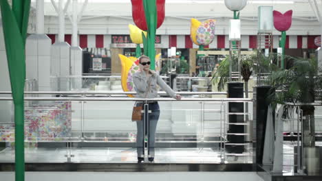 Una-Joven-Está-Hablando-Por-Teléfono-Móvil-En-El-Centro-Comercial.