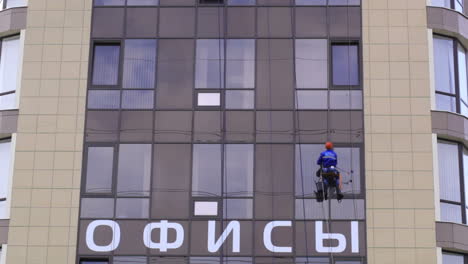 Man-washes-the-windows-of-office-building-2