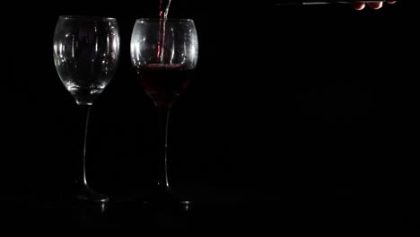 Rotwein-Wird-In-Zwei-Gläser-Auf-Schwarzem-Hintergrund-Gegossen