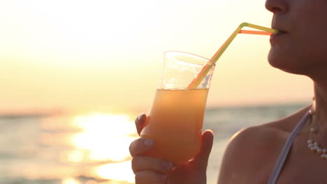 Woman-sipping-a-refreshing-cocktail-at-sunset