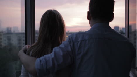 Young-couple-on-the-balcony-at-sunset