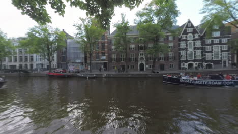 Vista-De-Amsterdam-Con-Barcos-En-El-Canal-Países-Bajos