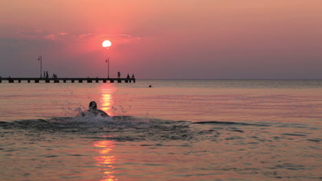 Hombre-Nadando-En-El-Mar-Al-Atardecer