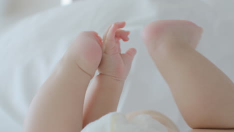 Baby-Liegt-Auf-Dem-Bett-Und-Berührt-Die-Füße