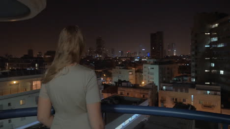 Frau-Genießt-Den-Blick-Auf-Die-Nächtliche-Stadt-Vom-Dach-Von-Tel-Aviv,-Israel