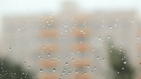 Focus-pulling-from-glass-with-rain-drops-to-the-building