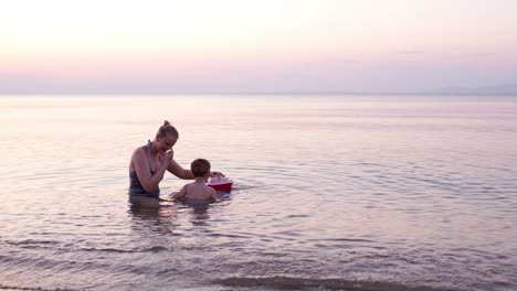 Mother-playing-with-young-son-with-toy-boat