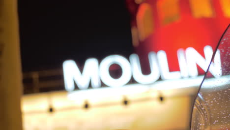 Vista-Del-Moulin-Rouge-A-Través-Del-Parabrisas-Mojado-De-La-Moto-Por-La-Noche-En-París
