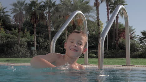 Joyful-kid-splashing-water-in-swimming-pool