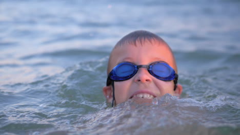 Fröhlicher-Junge-Mit-Schutzbrille,-Der-Im-Meer-Badet