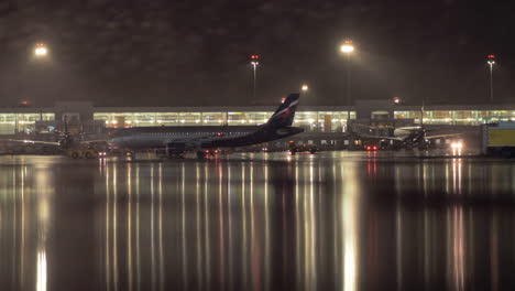Tow-pushbacking-Aeroflot-plane-in-Sheremetyevo-Airport-at-rainy-night-Moscow