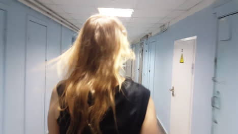 Woman-walking-in-empty-hallway-of-the-hospital