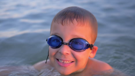 Lächelndes-Kind-Mit-Schutzbrille,-Das-Im-Meer-Schwimmt