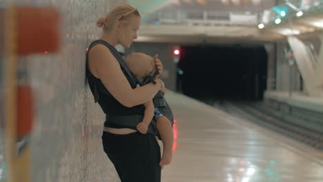 Mamá-Con-Bebé-Durmiendo-Esperando-El-Tren-En-El-Metro