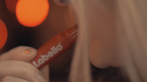 Young-woman-applying-Labello-lip-balm-stick