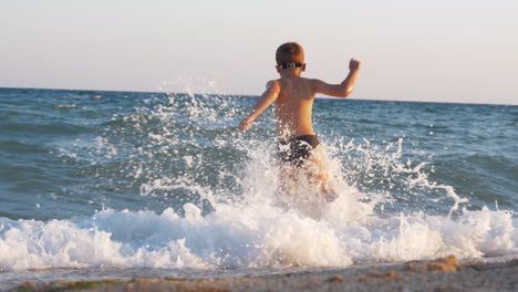 Kind-Genießt-Den-Urlaub-An-Der-Küste-Und-Rennt-Ins-Meer,-Um-Zu-Schwimmen