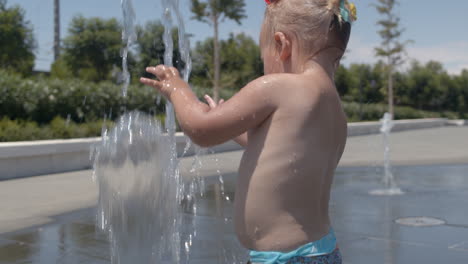 Kleines-Mädchen,-Das-Einen-Schönen-Sommertag-Hat-Und-Mit-Dem-Springbrunnen-Spielt