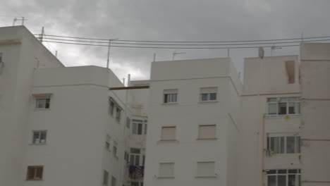 White-facade-apartment-house-with-shutters-on-windows