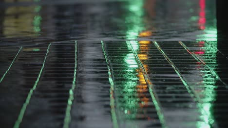 Evening-rain-road-lights-reflecting-on-wet-sidewalk