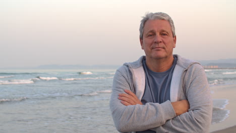 Hombre-Jubilado-Deportivo-Con-Retrato-De-Brazos-Cruzados-En-La-Playa