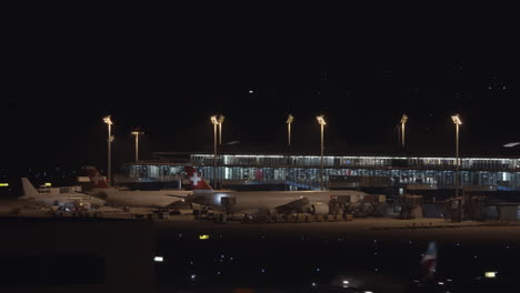 Aviones-De-Swiss-Airlines-En-El-Aeropuerto-Por-La-Noche.