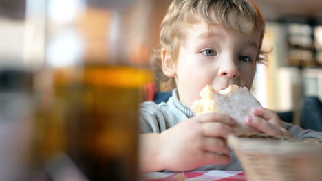 Süßer-Junge,-Der-Im-Café-Ein-Brötchen-Isst