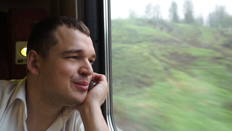 Young-man-having-exciting-phone-talk-in-the-train