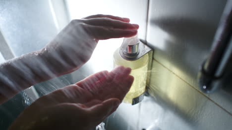 Manos-Femeninas-Empujando-Un-Recipiente-Con-Jabón-Líquido-Mientras-Se-Ducha