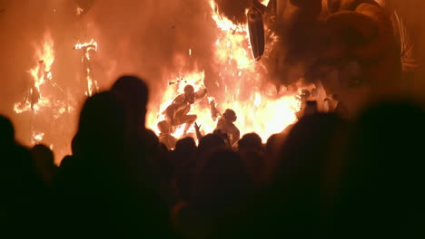 People-looking-at-ninot-in-fire-during-Fallas-celebration-in-Spain