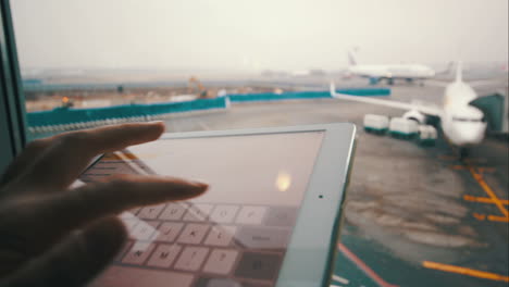 Using-touch-pad-by-the-window-at-airport