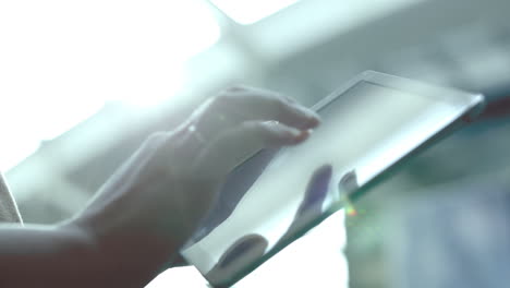 Woman-using-tablet-computer-against-bright-light