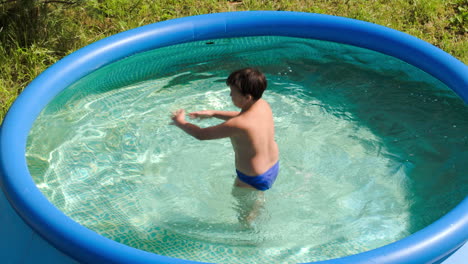 Boy-having-fun-in-outdoor-pool-on-a-hot-summer-day