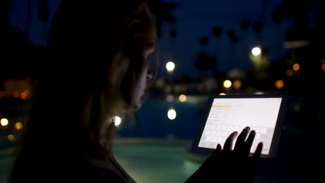 Woman-with-pad-on-tropical-resort-in-the-evening