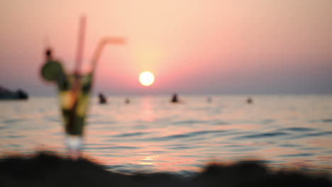 Menschen-Im-Meer-Und-Cocktail-Am-Strand-Bei-Sonnenuntergang