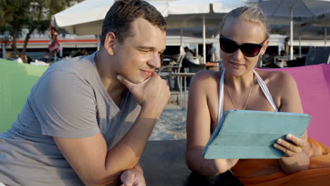 Hombre-Y-Mujer-Con-Tableta-En-La-Playa