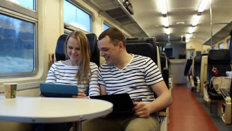 Woman-with-pad-and-man-laptop-talking-in-the-train