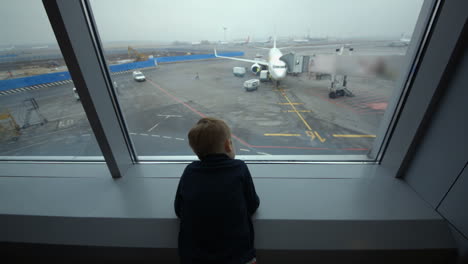 Kleiner-Junge,-Der-Am-Flughafen-Aus-Dem-Fenster-Schaut