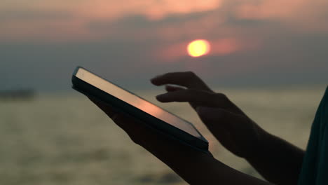 Mit-Touchpad-Am-Strand-Bei-Sonnenuntergang