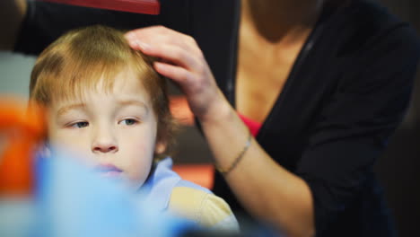 Friseur-Kämmt-Jungenhaare-Vor-Dem-Haarschnitt