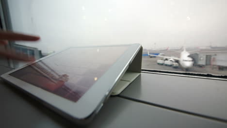 Usando-Tablet-Pc-En-El-Alféizar-De-La-Ventana-En-El-Aeropuerto