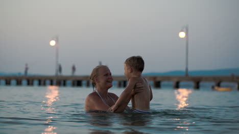 Mother-helping-son-to-jump-in-water