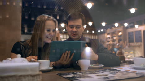 Young-people-in-a-cafe-looking-on-the-pad-and-talking