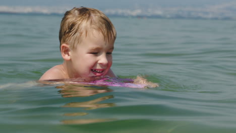 Kleiner-Junge,-Der-Versucht,-An-Bord-Im-Meer-Zu-Schwimmen
