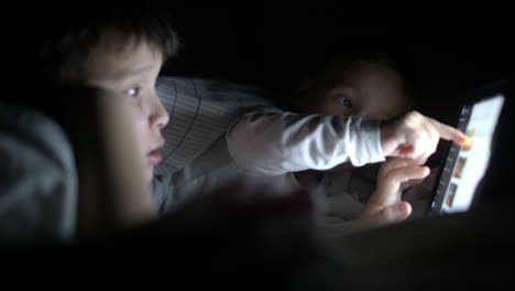 Dos-Niños-Pequeños-Intentan-Ver-La-Película-Por-La-Noche-Usando-Una-Tableta.