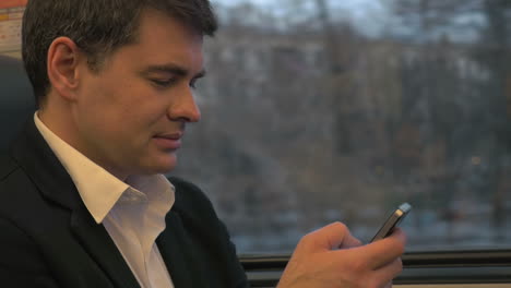 Businessman-Using-Smartphone-in-Train