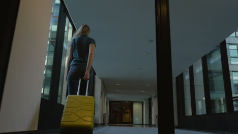 Woman-with-travel-bag-leaving-hotel