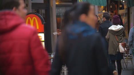 Woman-Eating-Fast-Food-by-the-Entrance-to-Restaurant