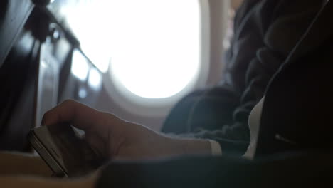 Man-watching-movie-on-smart-phone-in-plane